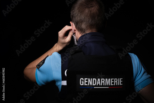 Un gendarme qui écoute un message à l'oreillette