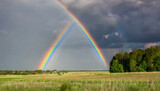 rainbow over stormy sky rural landscape with rainbow over dark stormy sky in a countryside at summer day