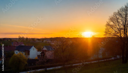 sunset over a little town orange sunbeams illuminate the houses beautiful time of a springday