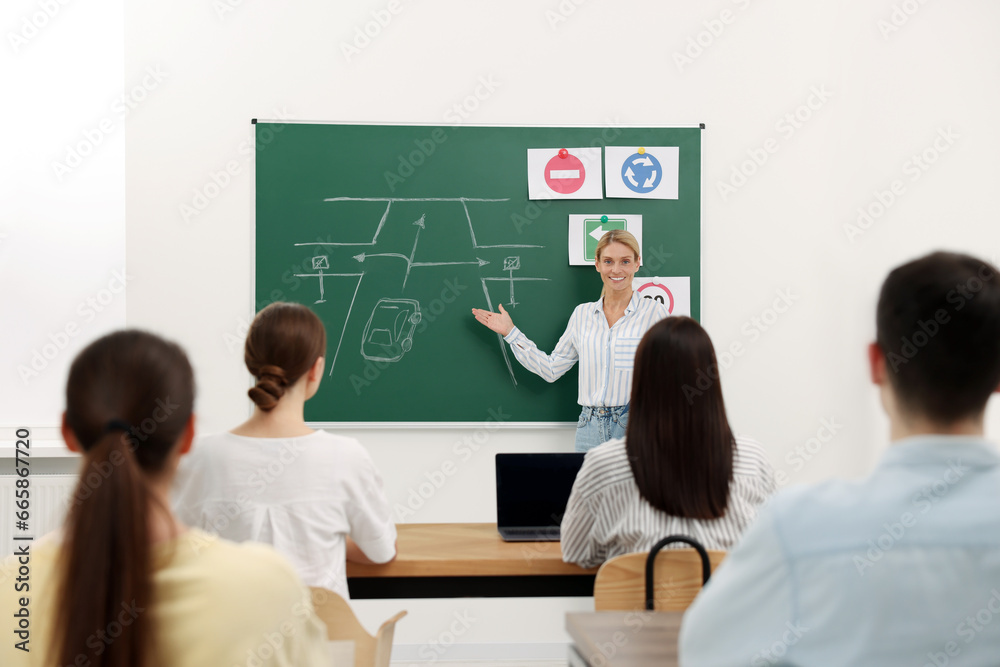 Teacher explaining traffic rules to audience during lesson in driving school Teacher explaining traffic rules to audience during lesson in driving school