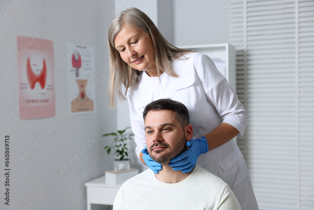 Endocrinologist examining thyroid gland of patient at hospital