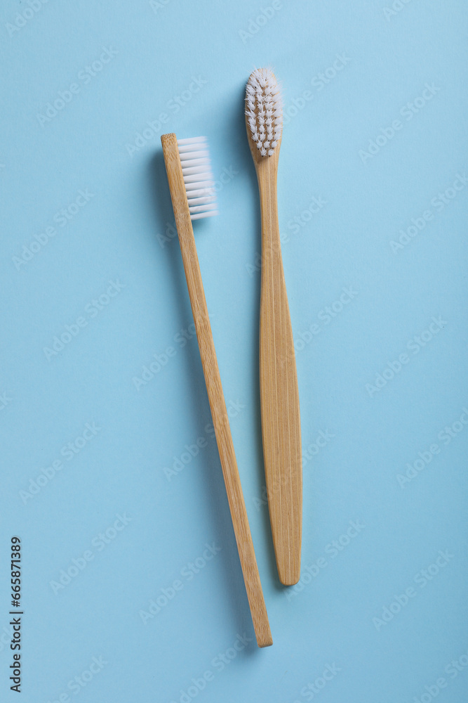 Bamboo toothbrushes on light blue background, flat lay Bamboo toothbrushes on light blue background, flat lay