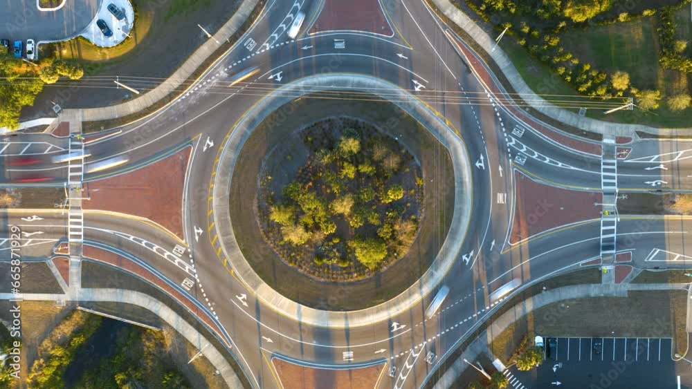 Top view of city street traffic on roundabout intersection with fast moving cars. Time-lapse of urban circular transportation crossroads