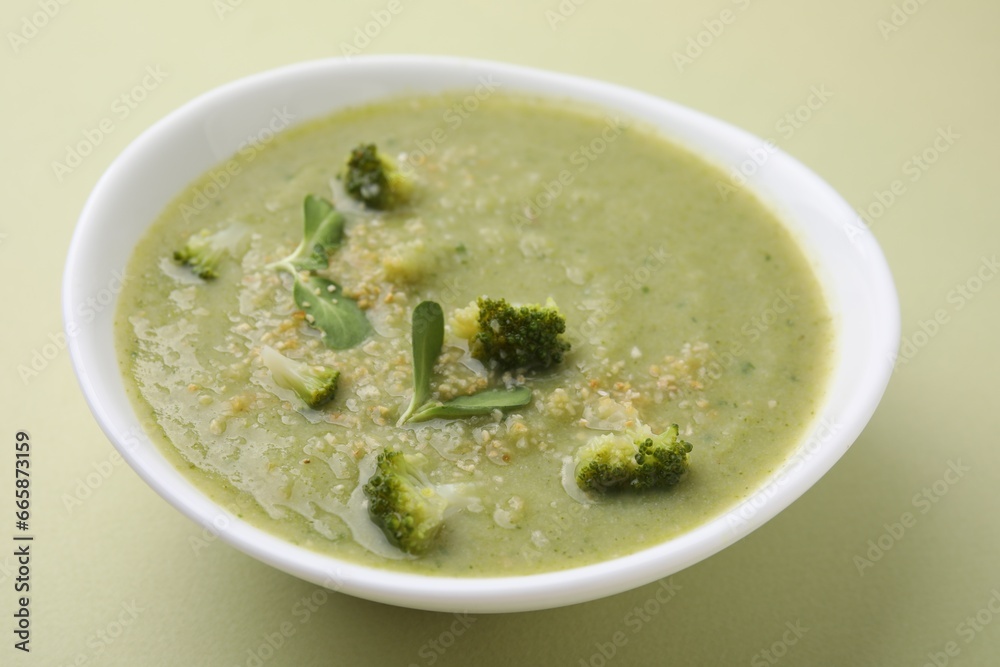 Delicious broccoli cream soup on olive background, closeup Delicious broccoli cream soup on olive background, closeup