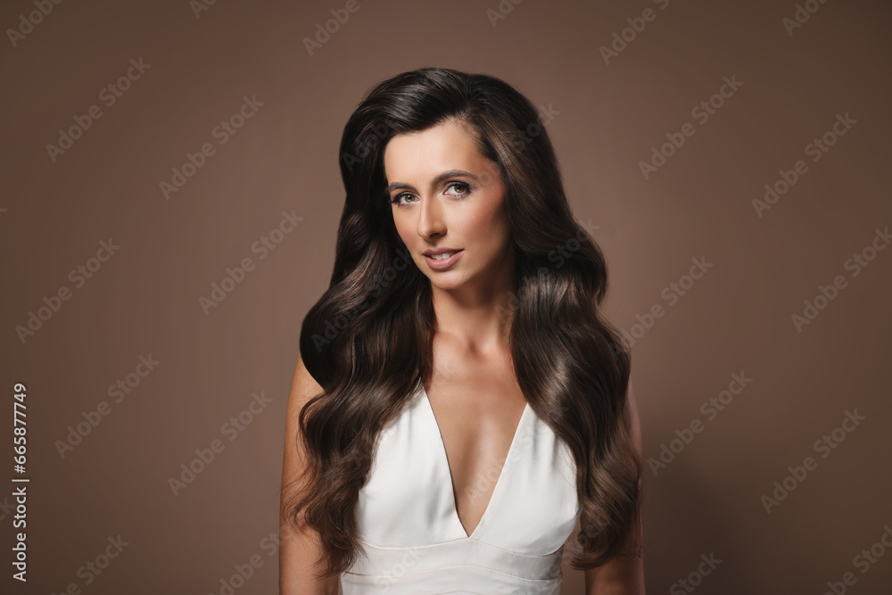Gorgeous woman with shiny wavy hair on brown background. Professional hairstyling Gorgeous woman with shiny wavy hair on brown background. Professional hairstyling