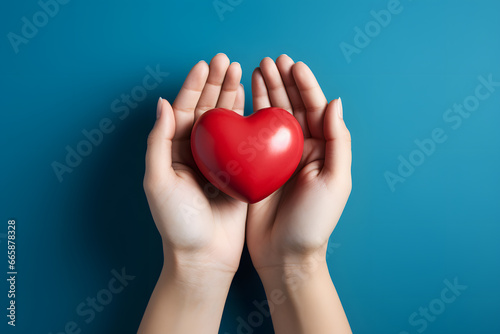 Adult hands holding red heart on light blue background