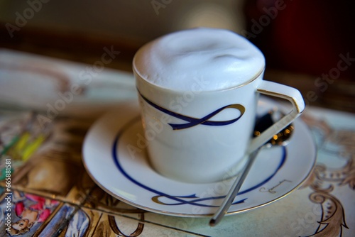 The Cup of cappuccino on a wooden table in a cafe. Beautiful foam, white ceramic cup, copy space.