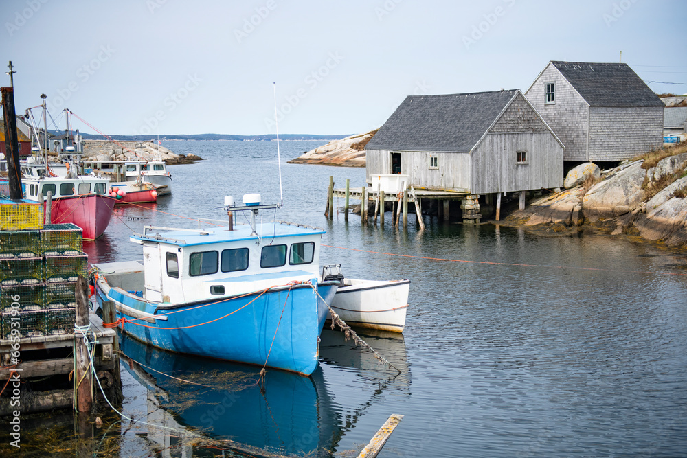 Fishing boats at iconic Peggy's Cove Lighthouse of Nova Scotia
