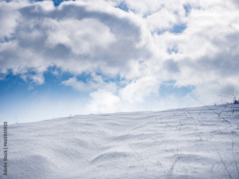 Snow hill and blue sky with clouds