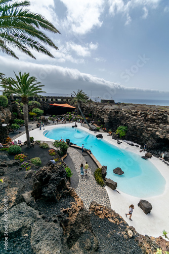 a view overlooking a man-made beach swimming pool on the volcanic island of Lanzarote.  © josehidalgo87
