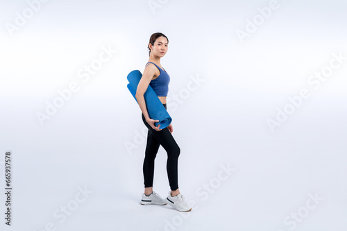 Young attractive asian woman portrait in sportswear with exercising mat. Healthy exercise and workout routine lifestyle concept. Studio shot isolated background. Vigorous © Summit Art Creations