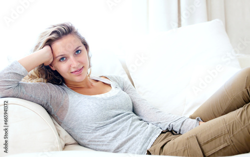 Woman, portrait and living room couch for lazy relax weekend, comfortable day off or cosy. Female person, face or tranquility solitude smile pose on apartment sofa for calm, positive mood in Canada