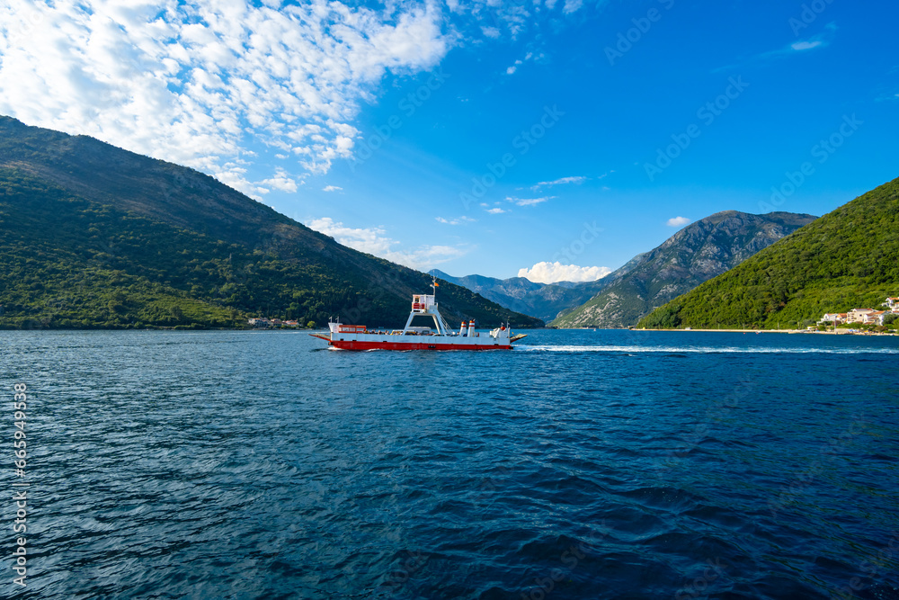 the ferry transports cars and passengers across the bay, beautiful nature with fjords and a small town in the distance the ferry transports cars and passengers across the bay, beautiful nature with fjords and a small town in the distance