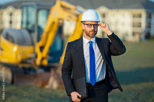 Engineer, construction manager or supervisor at a construction. Supervisor in suit and helmet. Investor, construction manager at a construction. Developer at construction site. Middle aged architect.