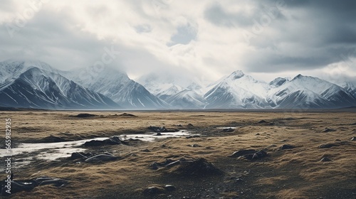 A barren tundra with snow-capped mountains in the distance. © Ai Studio