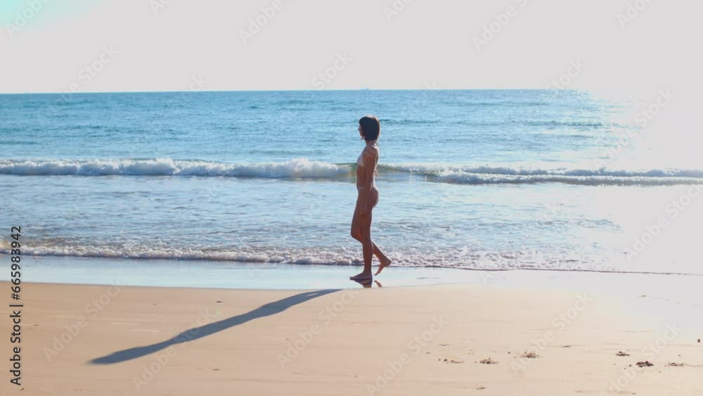 beautiful and slender girl in a white swimsuit walks along the beach. beautiful and slender girl in a white swimsuit walks along the beach.
