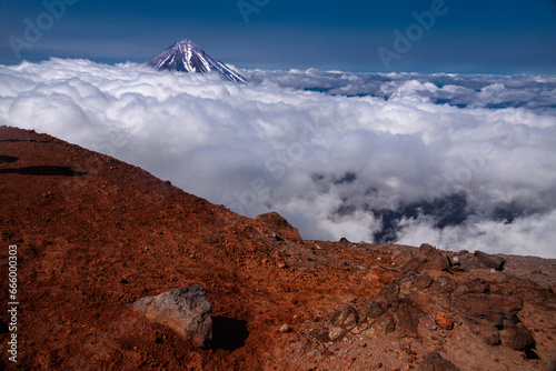 Kamchatka volcanic landscape: view to top of cone of Koryaksky Volcano from scenery active crater of Avacha Volcano on sunny day and blue sky. Russian Far East