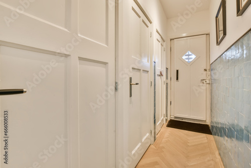 a long hallway with white walls and wood flooring on the left handrails are framed in black frames