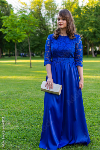 Cute teen girl with make up posing outdoor. Pretty female model in fashionable blue evening dress