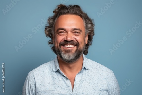 Middle-aged Caucasian man on blue background, cheerful and pleasant.