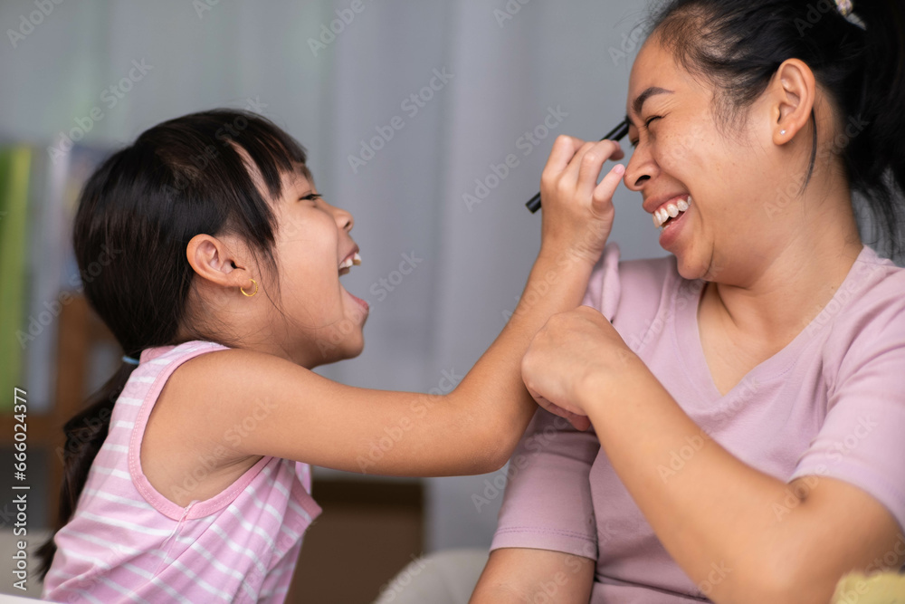Mother and daughter drawing together with crayons. Adult woman helps girl study or draw together at home in living room. Happy family. Mother and daughter drawing together with crayons. Adult woman helps girl study or draw together at home in living room. Happy family.