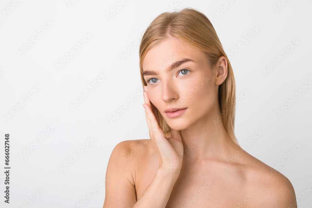 Young Blonde Woman Posing Touching Perfect Face Over White Background Young Blonde Woman Posing Touching Perfect Face Over White Background