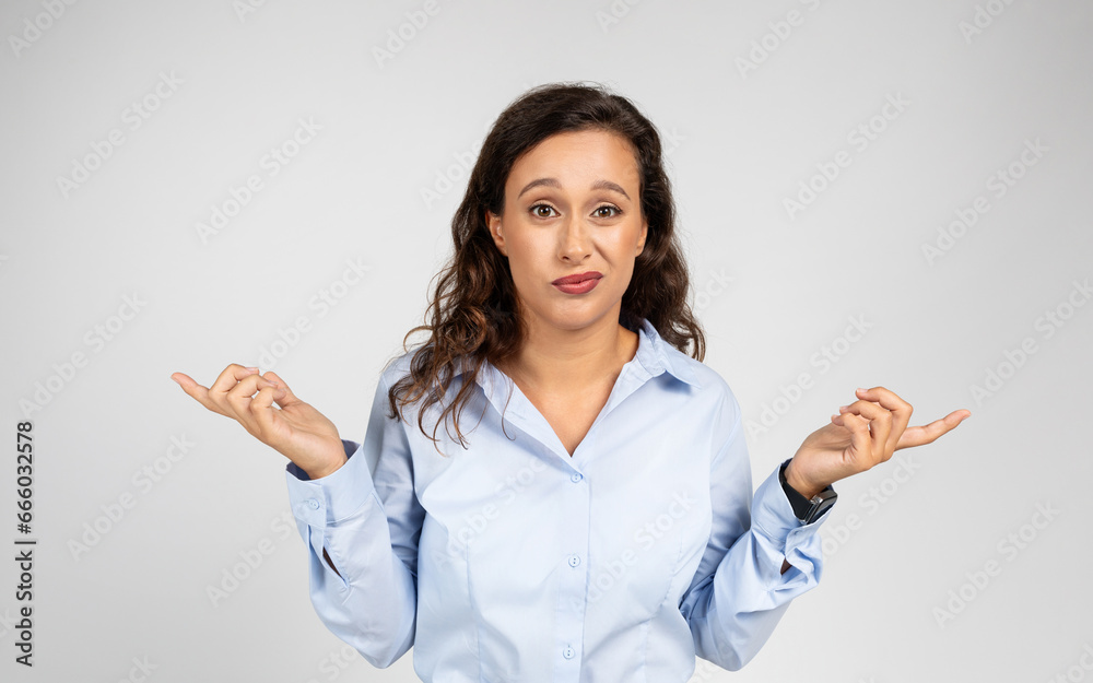 Confused adult european business woman in formal wear points fingers to sides at copy space Confused adult european business woman in formal wear points fingers to sides at copy space