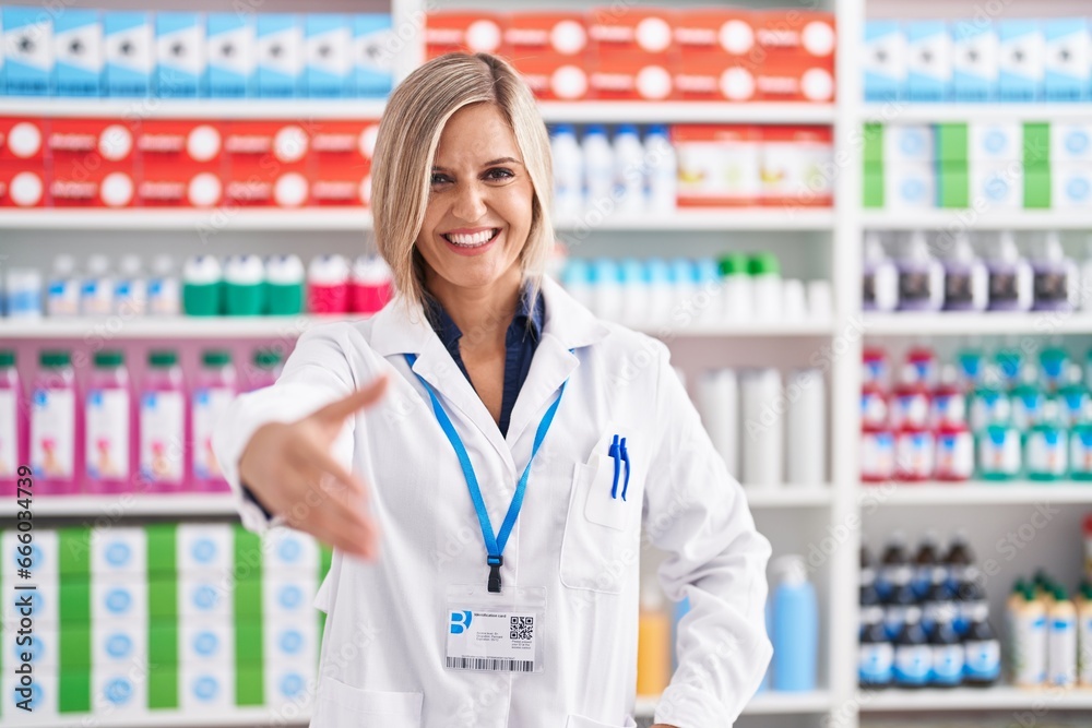 Young blonde woman pharmacist smiling confident shake hand at pharmacy Young blonde woman pharmacist smiling confident shake hand at pharmacy