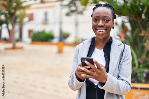 African american woman smiling confident using smartphone at park