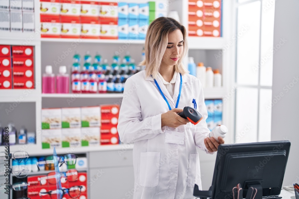 Young woman pharmacist scanning pills bottle at pharmacy