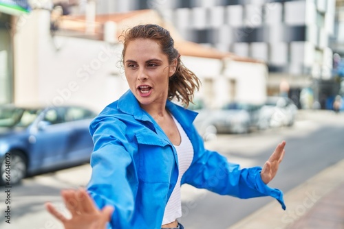 Young woman smiling confident dancing at street