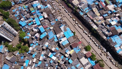 Aerial shot over Dharavi, largest slum in Asia as it reveals the cityscape with high rise buildings and coastline