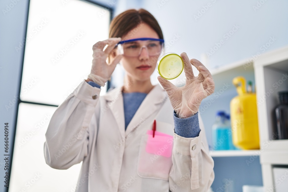 Young blonde woman scientist looking sample with serious expression at laboratory Young blonde woman scientist looking sample with serious expression at laboratory