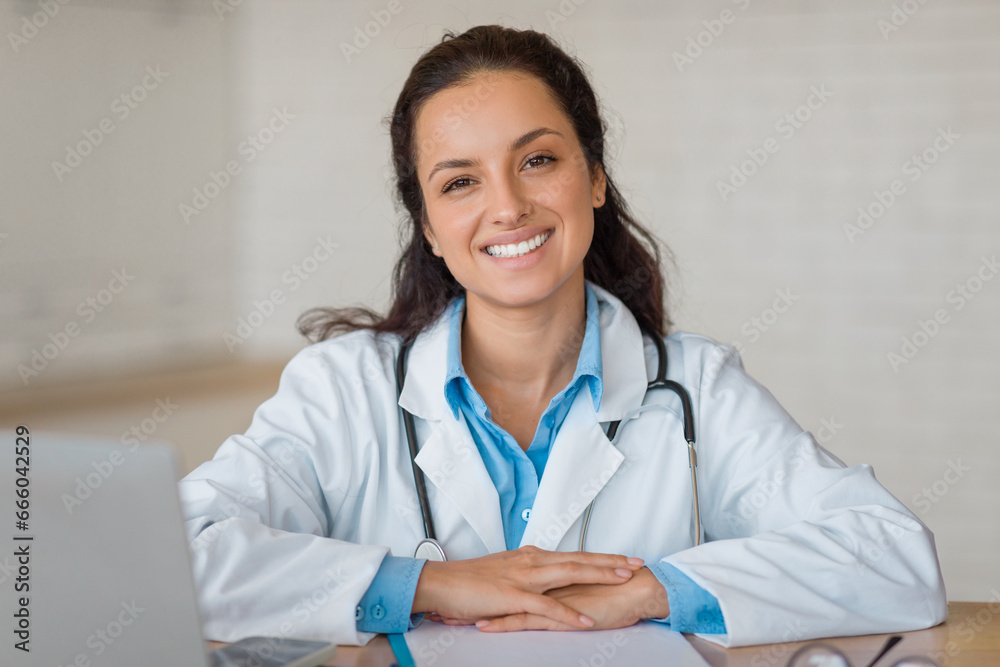Confident doctor with laptop, smiling at camera Confident doctor with laptop, smiling at camera