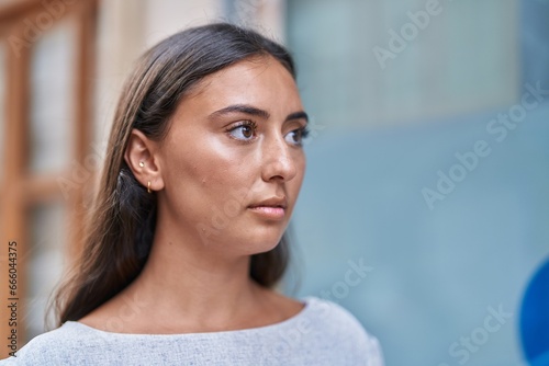 Young beautiful hispanic woman looking to the side with serious expression at street