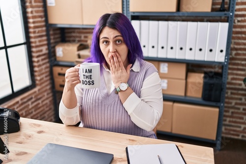 Fotografie Plus size woman wit purple hair working at small business ecommerce holding i am the boss cup covering mouth with hand, shocked and afraid for mistake