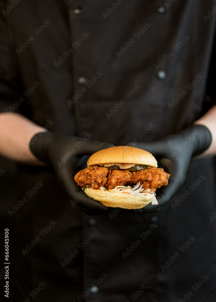 A craft juicy burger with cheese is held in the hands A craft juicy burger with cheese is held in the hands