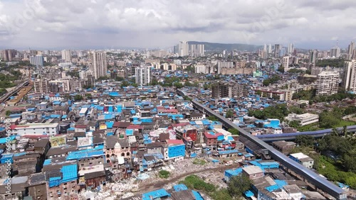 Aerial view of residential buildings in the crowded Dharavi neighbourhood in the the suburbs of Mumbai, Maharashtra, India, population growth, poverty and overpopulation concept.