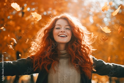 Red-haired woman walking through the park in the autumn