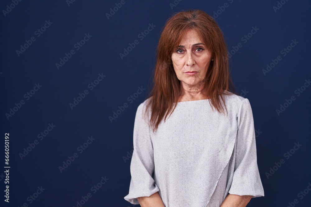 Middle age woman standing over blue background depressed and worry for distress, crying angry and afraid. sad expression. Middle age woman standing over blue background depressed and worry for distress, crying angry and afraid. sad expression.