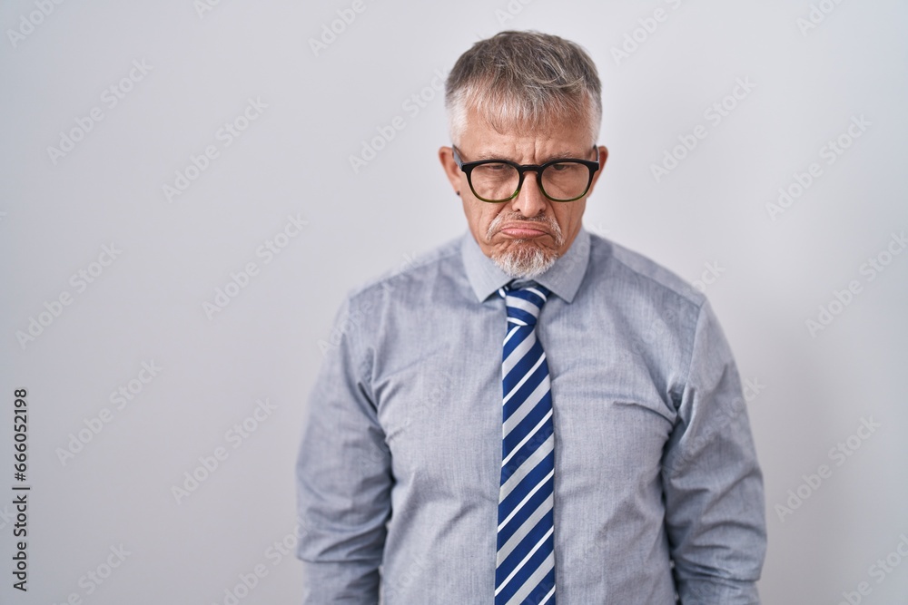 Hispanic business man with grey hair wearing glasses skeptic and nervous, frowning upset because of problem. negative person. Hispanic business man with grey hair wearing glasses skeptic and nervous, frowning upset because of problem. negative person.