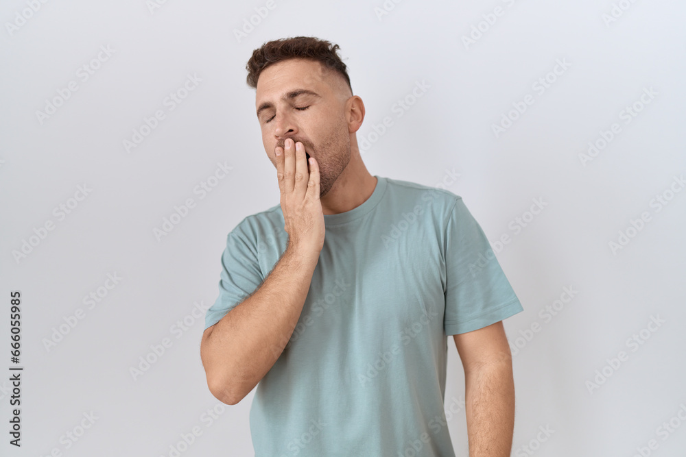 Hispanic man with beard standing over white background bored yawning tired covering mouth with hand. restless and sleepiness. Hispanic man with beard standing over white background bored yawning tired covering mouth with hand. restless and sleepiness.