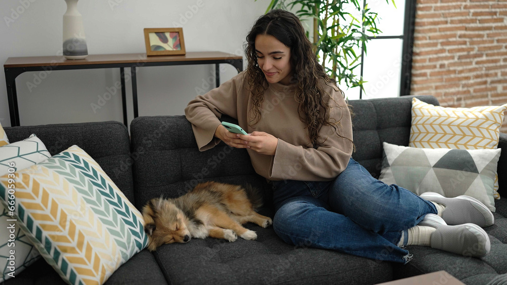 Young hispanic woman with dog make photo by smartphone to asleep dog at home Young hispanic woman with dog make photo by smartphone to asleep dog at home