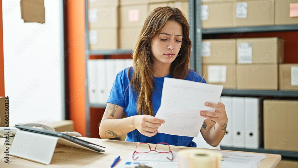 Young beautiful hispanic woman ecommerce business worker reading document at office Young beautiful hispanic woman ecommerce business worker reading document at office