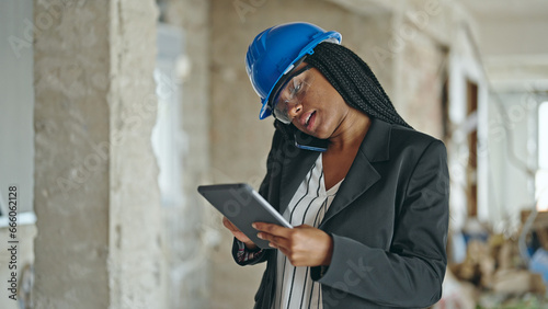 African american woman architect using touchpad talking on smartphone at construction site © Krakenimages.com