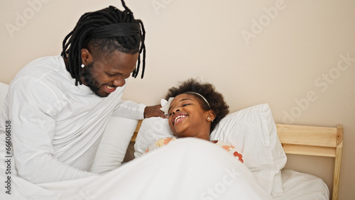 African american father and daughter lying on bed laughing a lot for tickles at bedroom