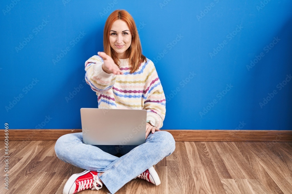 Φωτογραφία Young woman using laptop at home sitting on the floor smiling cheerful offering palm hand giving assistance and acceptance