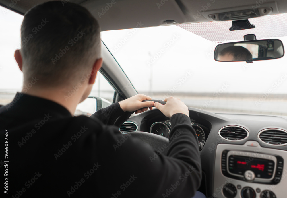 close up young male person driving a car, holding steering wheel, start the journey