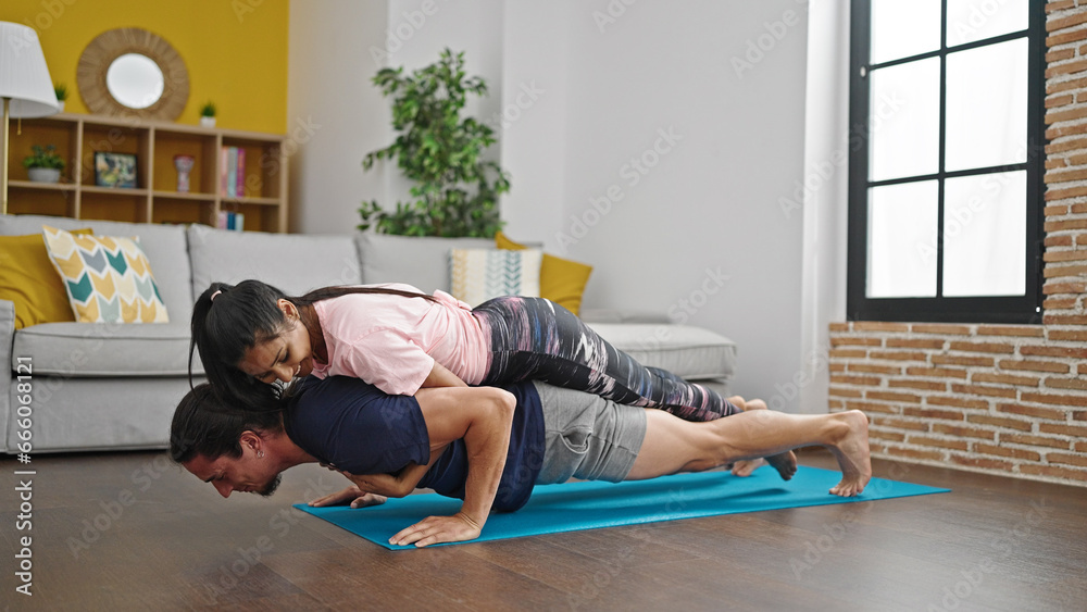 Man and woman couple training push up with girlfriend on back at home Man and woman couple training push up with girlfriend on back at home