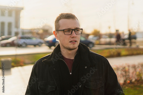 portrait of young handsome man wearing eyeglasses in the street on a summer day